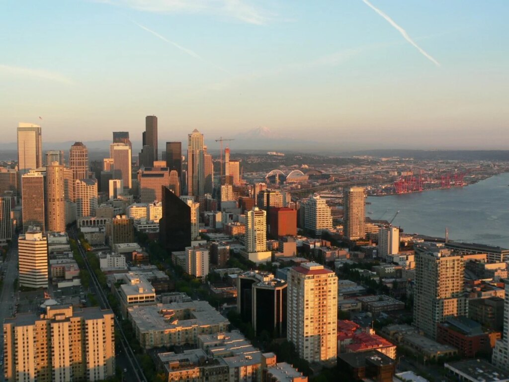 Two activists lower the flags of Israel and America and raise the flag of Palestine in Seattle