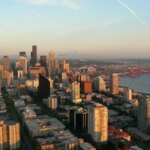 Two activists lower the flags of Israel and America and raise the flag of Palestine in Seattle